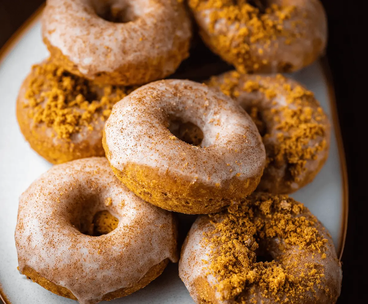 Delicious baked pumpkin spice donuts topped with cinnamon and glaze, perfect for fall treats