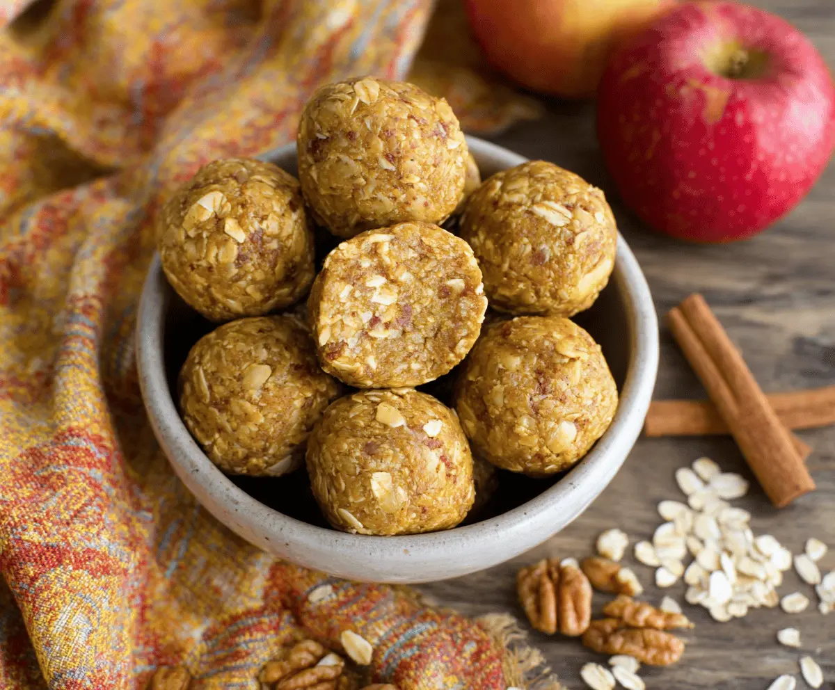 Delicious homemade apple cinnamon pumpkin protein balls on a white plate, featuring a festive fall-inspired snack with pumpkin, cinnamon, and apple flavors