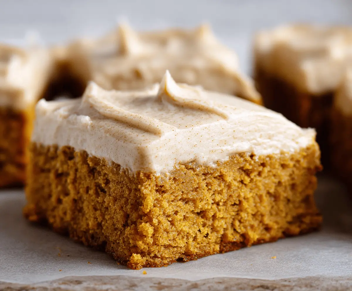 Delicious homemade pumpkin bars topped with creamy brown sugar frosting on a festive plate, perfect for fall dessert